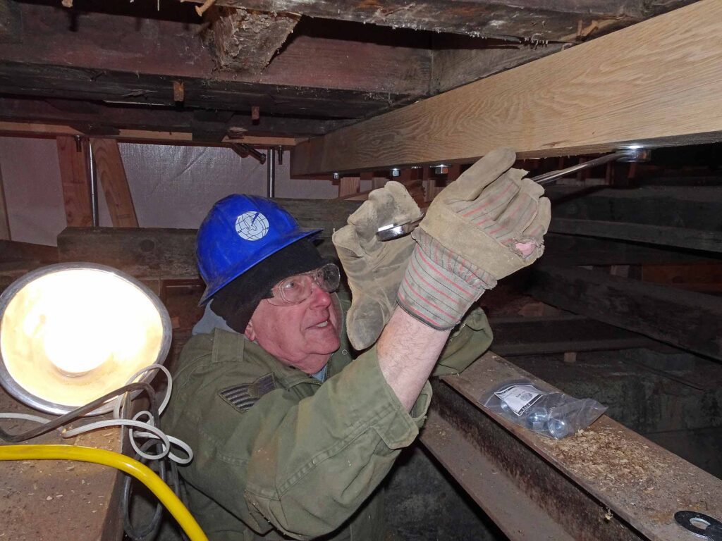 Image of a man attaching a piece of wood to a train