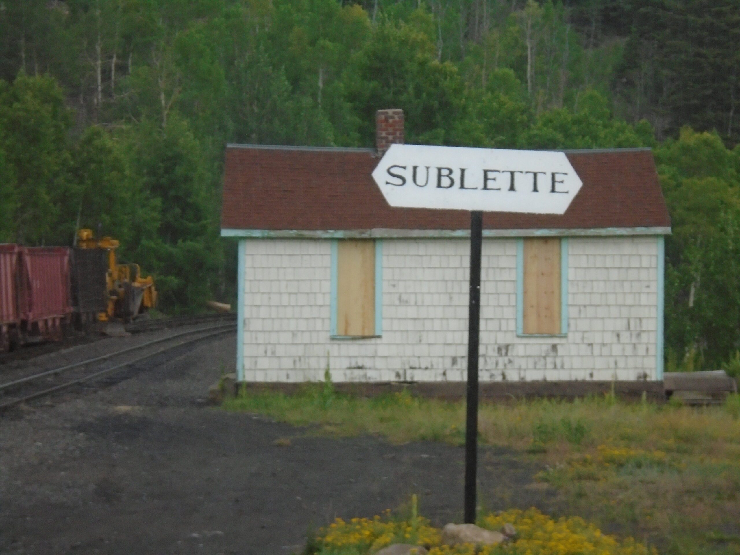 Image of an old train station with a sign that reads SUBLETTE